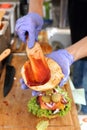 Making burgers. Preparing a hamburger in a protective gloves, in a food truck, in a fast food restaurant, close up.