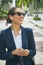 Making business plans on the move. a young businesswoman her phone and earphones while out in the city. Royalty Free Stock Photo