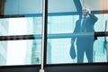 Making the calls that lead to success. a mature businessman using a mobile phone in a modern glass office. Royalty Free Stock Photo