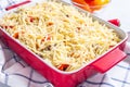 Making casserole with potatoes, sausage and colorful bell pepper, raw in baking dish, horizontal Royalty Free Stock Photo