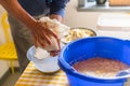 Making of Cepelinai - Zeppelins is national Lithuanian dish. Mans hands draining grated potatoes. Squeezing gauze with potatoes Royalty Free Stock Photo