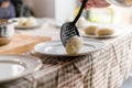 Making of Cepelinai - Zeppelins is national Lithuanian dish. Woman hand serving hot zeppelins on a plate at home Royalty Free Stock Photo