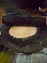 Making chapathi using wheat flour and using plank and roller for making it in round shape. Royalty Free Stock Photo