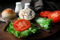 Making chicken sandwich with tomatoes, green salad, yogurt based sauce and mustard Royalty Free Stock Photo