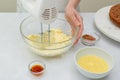 Making the chocolate cake frosting. Woman hands beating butter in a glass bowl using an electric hand mixer Royalty Free Stock Photo