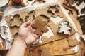 Making christmas gingerbread cookies. Hand holding raw gingerbread man cookie on background of dough, metal cutters and anise, Royalty Free Stock Photo