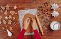 Making Christmas gingerbread in the different form on a brown wooden background. cutting man shapes in cookie dough Royalty Free Stock Photo