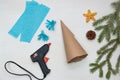 Making a Christmas tree out of paper. Scissors, blue paper, glue, paper cone and fir branches on a light table. An original Royalty Free Stock Photo