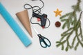 Making a Christmas tree out of paper. Scissors, hot glue gun, blue paper, cone and fir branches on a light table. An original Royalty Free Stock Photo