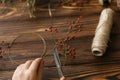 Making christmas wreath on rustic wooden table, holiday advent