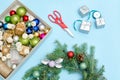 Making a Christmas wreath. Spruce branch, ornaments, scissors. B Royalty Free Stock Photo