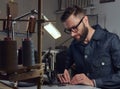 Making clothes. tailor sitting at table and working on a sewing machine at the sewing workshop. Royalty Free Stock Photo