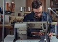 Making clothes. tailor sitting at table and working on a sewing machine at the sewing workshop. Royalty Free Stock Photo