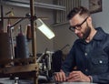 Making clothes. tailor sitting at table and working on a sewing machine at the sewing workshop. Royalty Free Stock Photo