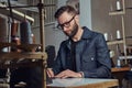 Making clothes. tailor sitting at table and working on a sewing machine at the sewing workshop. Royalty Free Stock Photo