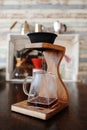 Making coffee in black paperless porous ceramic porcelain filter on wooden coffee station. Brewing devices in background Royalty Free Stock Photo