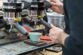 Making coffee in coffee machine. Man`s hands prepares coffee, fresh espresso pours into porcelain cup. Service and Royalty Free Stock Photo