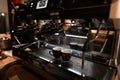 Making coffee with an espresso machine. Hot delicious espresso flows into two black cups. Modern technology for making coffee Royalty Free Stock Photo