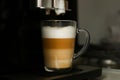 Making coffee in a coffee machine at home. Boil and beat process. The finished coffee has three layers of white, beige
