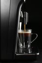Making coffee with modern espresso machine on grey table against black background Royalty Free Stock Photo