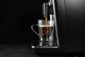Making coffee with modern espresso machine on grey table against black background. Space for text Royalty Free Stock Photo