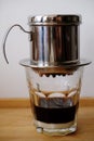 Making coffee in a Vietnamese phin with condensed milk in a glass Royalty Free Stock Photo