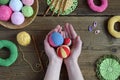 Making colored crochet balls. Toy for babies and toddlers to learn mechanical skills and colors. On the table threads, needles, Royalty Free Stock Photo