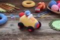 Making colored crochet racing car. Toy for babies and toddlers to learn mechanical skills and colors. On the table threads, Royalty Free Stock Photo