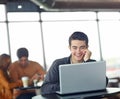 Making connections online. A handsome young man using his laptop in a coffee shop.