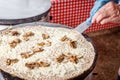 Making crepes pancakes at a food market. A hand is making crepes outdoors with melted cheese and mushrooms on a metal griddle