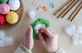 Making crochet pyramid from colored rings. Toy for babies and toddlers to learn mechanical skills and colors. On the table threads Royalty Free Stock Photo