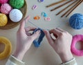 Making crochet pyramid from colored rings. Toy for babies and toddlers to learn mechanical skills and colors. On the table threads Royalty Free Stock Photo