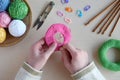 Making crochet pyramid from colored rings. Toy for babies and toddlers to learn mechanical skills and colors. On the table threads Royalty Free Stock Photo