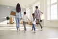 Family carrying cardboard boxes and together entering their new house on moving day Royalty Free Stock Photo