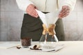 Making drip coffee. Woman setting paper filter into glass chemex coffeemaker at table, closeup Royalty Free Stock Photo