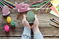 Making Easter decoration - easter eggs and bunny. Painting and coloring wooden toy of brushes and gouache. Creative process.