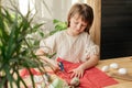 Making Easter eggs in the shape of a hare from textile. The girl prepares the fabric, cuts it with scissors. Home