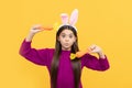 making faces. funny child in hare ears hold carrot. teenager girl wear rabbit costume Royalty Free Stock Photo