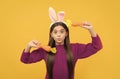 making faces. funny child in hare ears hold carrot. teenager girl wear rabbit costume Royalty Free Stock Photo