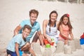 Making a family masterpiece out of sand. a happy family building sandcastles together at the beach. Royalty Free Stock Photo