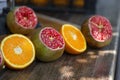 Making of fresh juice. Green ripe pomegranates and oranges on the table. Sliced fruits. Healthy organic products. Royalty Free Stock Photo