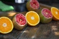 Making of fresh juice. Green ripe pomegranates and oranges on the table. Sliced fruits. Healthy organic products. Royalty Free Stock Photo