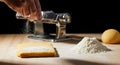 Making Fresh Pasta Hand Sprinkling Flour onto Dough with Machine and Ingredients Royalty Free Stock Photo