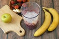 Making Fruit Smoothie with banana, blueberry, apple, strawberry and milk. Blender filled with fresh whole fruits for making a Royalty Free Stock Photo