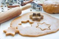 Making gingerbread cookies. Dough, metal cutter and rolling pen on wooden table, spices on background