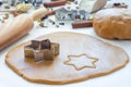 Making gingerbread cookies. Dough, metal cutter and rolling pen on wooden table, spices on background