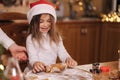 Making gingerbread at home. Little girl cutting cookies of gingerbread dough. Christmas and New Year traditions concept Royalty Free Stock Photo