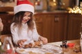Making gingerbread at home. Little girl cutting cookies of gingerbread dough. Christmas and New Year traditions concept Royalty Free Stock Photo