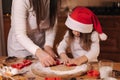 Making gingerbread at home. Little girl with her mom cutting cookies of gingerbread dough. Christmas and New Year Royalty Free Stock Photo