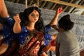 A girl painting goddess Durga idol for Durga puja